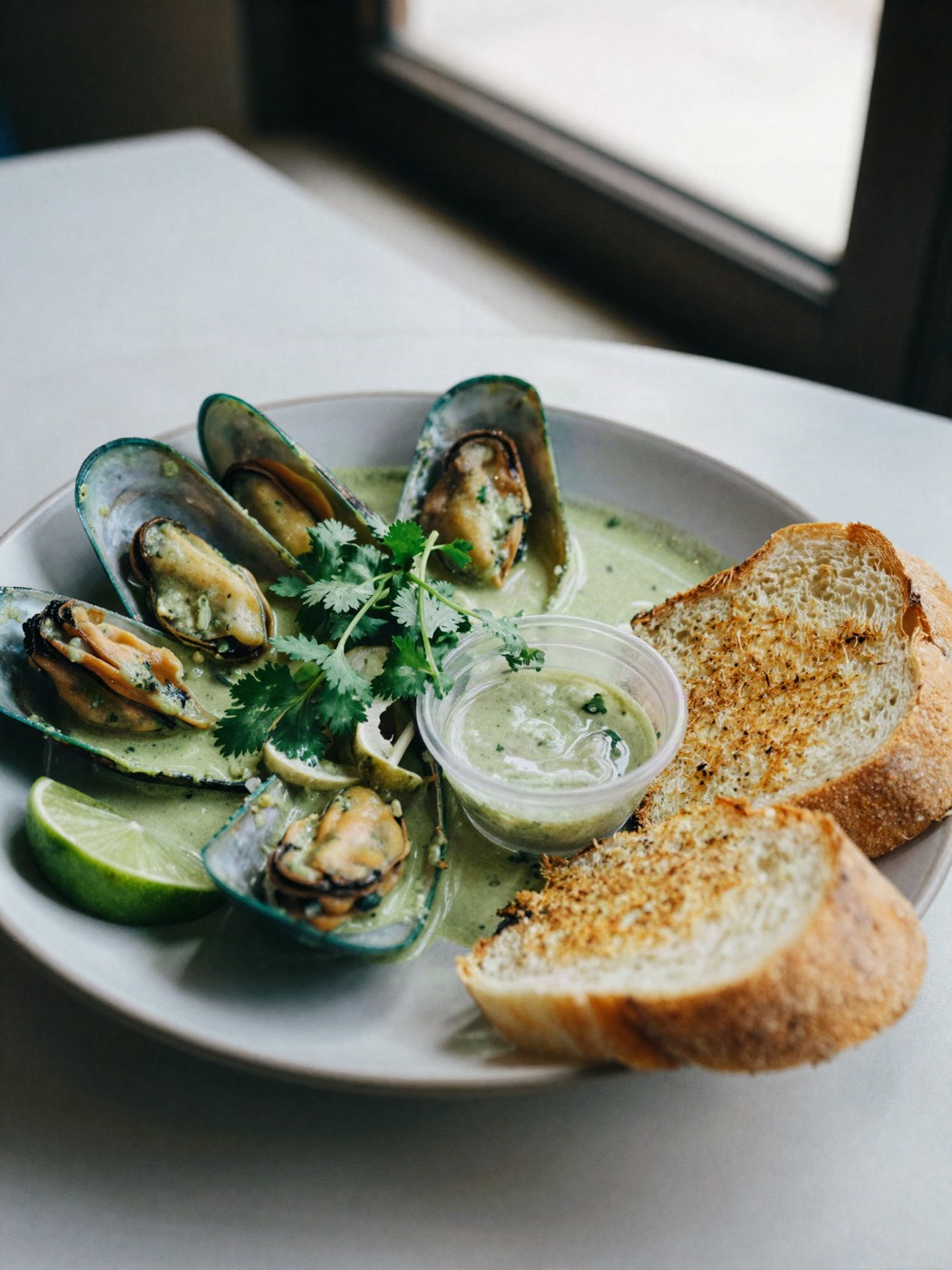 Mejillones en curry verde con cilantro, lima y pan tostado